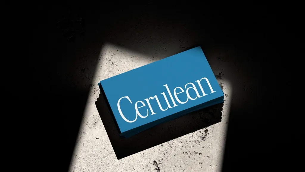 Blue printed cards with the Cerulean wordmark in white, on a sunlit stone surface.