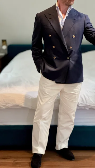 John Philip Green in a navy double-breasted blazer and cream trousers.