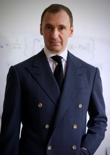 Portrait of John Philip Green in a navy double-breasted suit and dark tie.