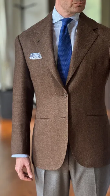 Detail of John Philip Green’s brown checked jacket, blue tie and pocket square.